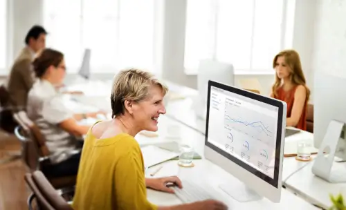 A woman focused on her computer, diligently working in a modern office environment.