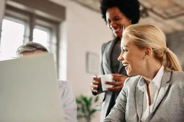 A diverse group of business professionals engaged in discussion around a conference table.